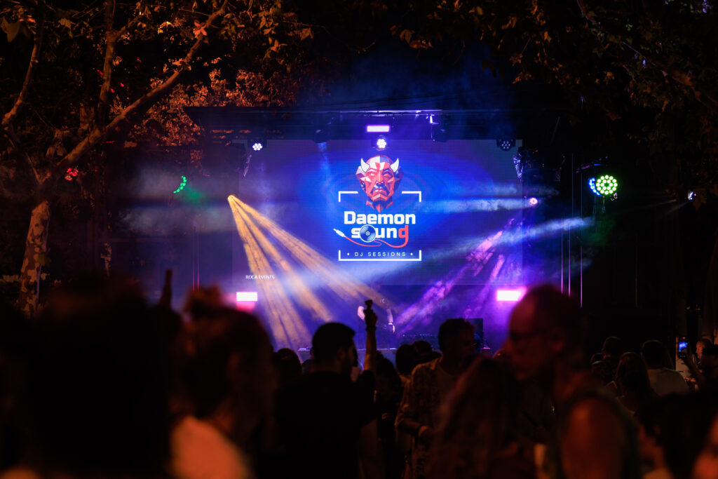 imagen del escenario Roca Event mostrando una sesion de DJ y el logotipo de Daemon Sound que es un demonio con un disco